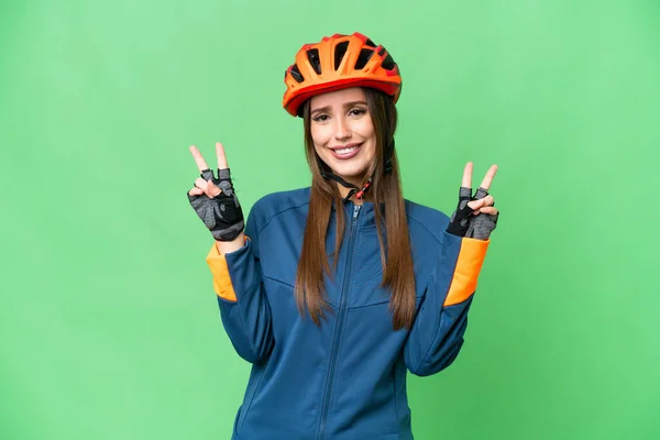 Young Cyclist Woman Isolated Chroma Key Background Showing Victory Sign — Stockfoto