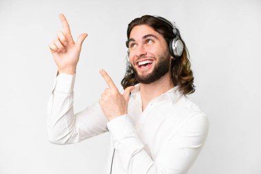 Telemarketer man working with a headset over isolated white background pointing with the index finger a great idea
