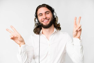 Telemarketer man working with a headset over isolated white background showing victory sign with both hands