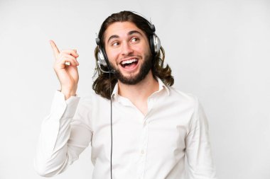 Telemarketer man working with a headset over isolated white background intending to realizes the solution while lifting a finger up