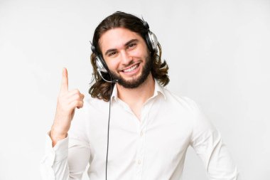 Telemarketer man working with a headset over isolated white background showing and lifting a finger in sign of the best