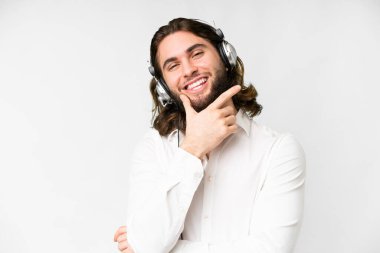 Telemarketer man working with a headset over isolated white background smiling