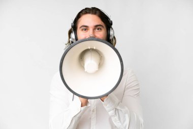 Telemarketer man working with a headset over isolated white background shouting through a megaphone