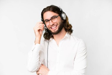 Telemarketer man working with a headset over isolated white background with glasses and happy