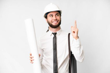 Young architect man with helmet and holding blueprints over isolated white background pointing up a great idea