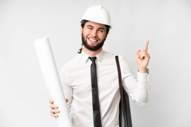 Young architect man with helmet and holding blueprints over isolated white background showing and lifting a finger in sign of the best