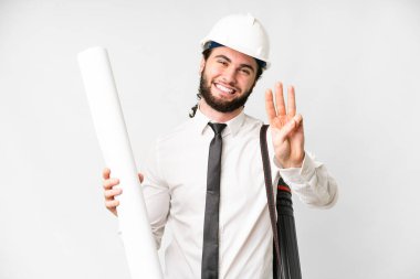 Young architect man with helmet and holding blueprints over isolated white background happy and counting three with fingers