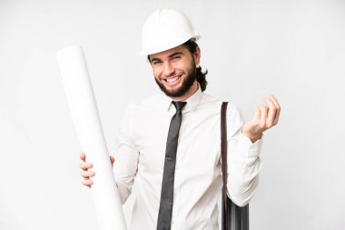 Miğferli genç bir mimar, izole edilmiş beyaz arka plan üzerinde planları tutuyor ve para hareketi yapıyor.