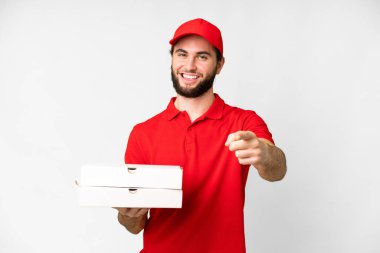 pizza delivery man with work uniform picking up pizza boxes over isolated white background pointing front with happy expression