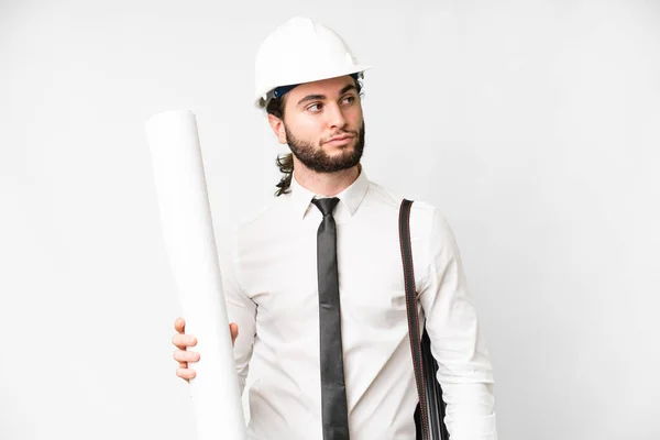 Young Architect Man Helmet Holding Blueprints Isolated White Background Looking — Foto Stock