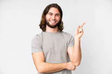 Genç yakışıklı, soyutlanmış beyaz arka plan mutlu ve yukarıya bakıyor.