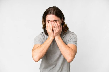 Genç yakışıklı, soyutlanmış beyaz bir arka plan, yorgun ve hasta bir yüz ifadesi var.