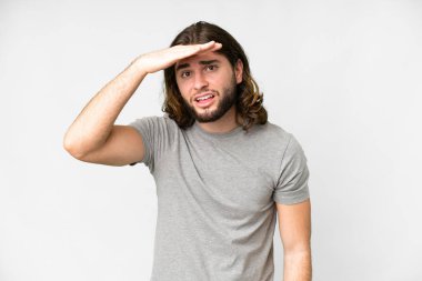 Soyutlanmış beyaz arka planda genç yakışıklı bir adam. Bir şeye bakmak için çok uzaklara bakıyor.