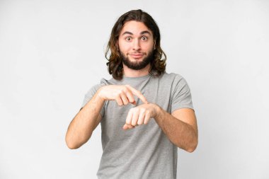 Soyutlanmış beyaz arka planda genç yakışıklı adam geç kalma jesti yapıyor.