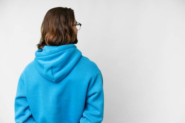 Genç yakışıklı adam izole edilmiş beyaz arka planda ve geriye bakıyor