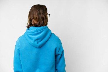 Young handsome man over isolated white background in back position and looking side