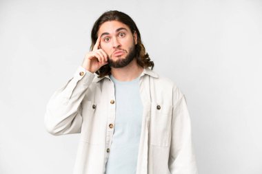 Soyutlanmış beyaz arka planda genç yakışıklı bir adam bir fikir düşünüyor.