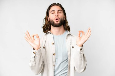 Zen pozisyonunda soyutlanmış beyaz bir geçmişi olan yakışıklı bir genç.