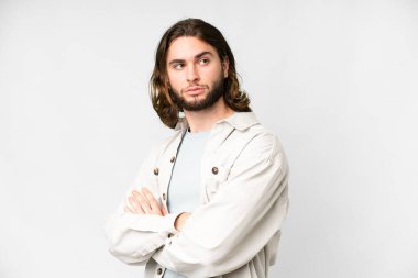 Young handsome man over isolated white background keeping the arms crossed