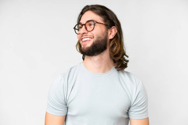 Genç yakışıklı, soyutlanmış beyaz bir arka plan ve mutlu bir ifadesi olan gözlüklü.