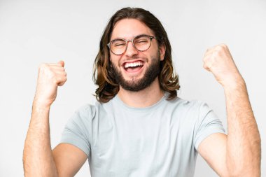 Young handsome man over isolated white background With glasses and celebrating a victory