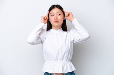 Young Chinese woman isolated on white background having doubts and thinking
