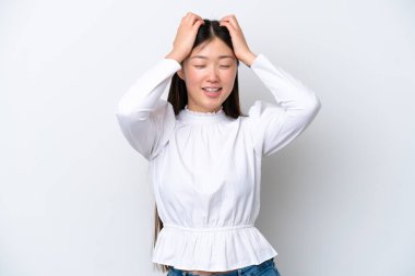 Genç Çinli bir kadın beyaz arka planda yalnız gülüyor.