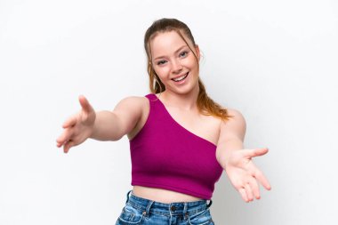 Young caucasian girl isolated on white background presenting and inviting to come with hand
