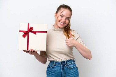 Beyaz arka planda izole edilmiş bir hediye tutan beyaz bir kadın. Başparmakları havada. Çünkü iyi bir şey oldu.