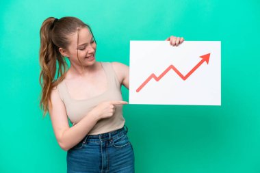 Yeşil arka planda izole edilmiş beyaz bir kadın elinde büyüyen bir istatistik okunun sembolü olan bir tabela tutuyor ve onu işaret ediyor.