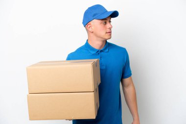 Young delivery Brazilian man isolated ops white background looking to the side
