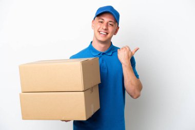 Young delivery Brazilian man isolated ops white background pointing to the side to present a product