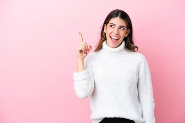 Pembe arka planda izole edilmiş genç İtalyan kadın parmağını kaldırarak çözümü anlamaya çalışıyor.