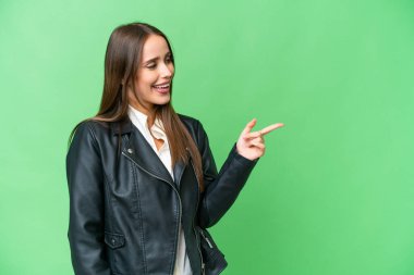 Young beautiful woman over isolated chroma key background pointing finger to the side and presenting a product