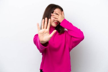 Beyaz arka planda izole edilmiş genç Ukraynalı kadın jesti durdurup yüzünü kapatıyor.