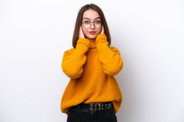 Beyaz arka planda izole edilmiş genç Ukraynalı kadın hayal kırıklığına uğramış ve kulaklarını kapatmış.