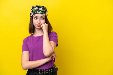 Young Ukrainian woman isolated on yellow background with tired and bored expression
