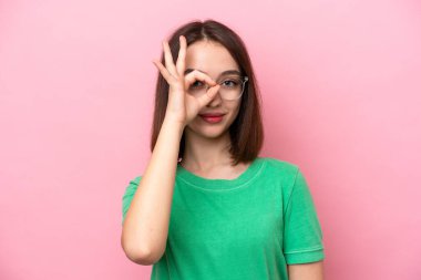 Genç Ukraynalı bir kadın pembe arka planda izole edilmiş, mutlu bir ifadeyle gözlüklü.