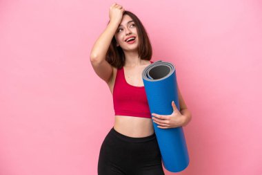 Young sport Ukrainian woman going to yoga classes while holding a mat isolated on pink background has realized something and intending the solution