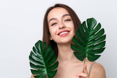 Beyaz arka planda izole edilmiş genç Ukraynalı bir kadın elinde mutlu bir ifadeyle bir palmiye yaprağı tutuyor. Portreyi kapat