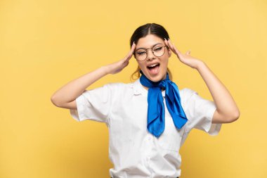 Airplane stewardess isolated on yellow background with surprise expression