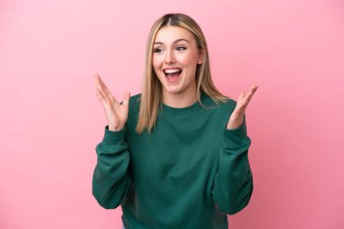 Pembe arka planda yalıtılmış beyaz bir kadın. Şaşırtıcı bir yüz ifadesi var.