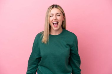 Pembe arka planda izole edilmiş beyaz bir kadın ağzı açık bağırıyor.