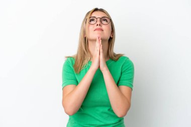 Beyaz arka planda izole edilmiş genç beyaz kadın avuç içlerini bir arada tutuyor. İnsan bir şey ister.