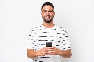 Beyaz arka planda yaşayan yakışıklı Arap bir adam şaşırdı ve bir mesaj gönderiyor.