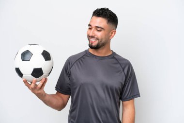 Arap futbolcu genç adam beyaz arka planda izole edilmiş, yan tarafa bakıyor ve gülümsüyor.