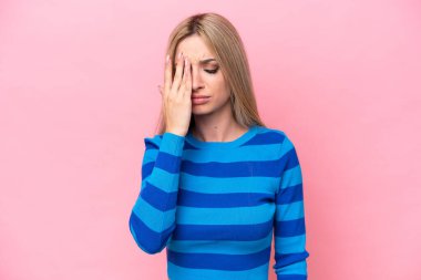 Güzel sarışın kadın pembe arka planda baş ağrısı ile izole edilmiş
