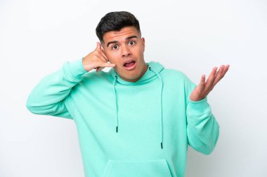 Beyaz arka planda izole edilmiş beyaz tenli yakışıklı bir adam telefon jesti yapıyor ve şüpheli.