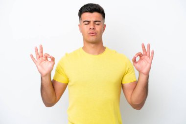 Beyaz arka planda Zen pozisyonunda beyaz tenli yakışıklı bir adam.