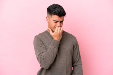 Pembe arka planda izole edilmiş beyaz, yakışıklı genç bir adam. Şüpheleri var.